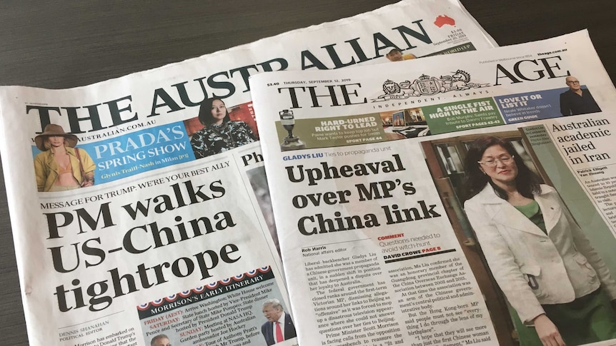 Two newspapers, The Australian and The Age, lying on a table.