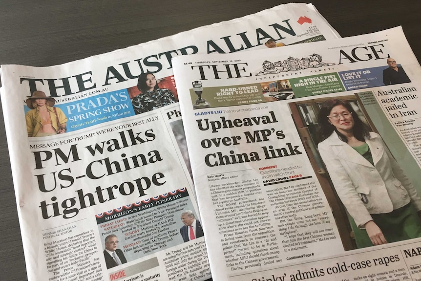 Two newspapers, The Australian and The Age, lying on a table.
