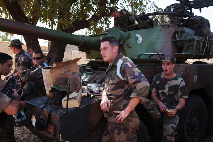 French soldiers stand next to a tank at a Malian air base in Bamako.