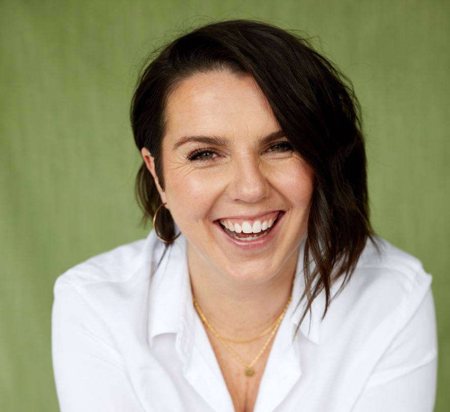 woman in white shirt and black hair smiling at camera 