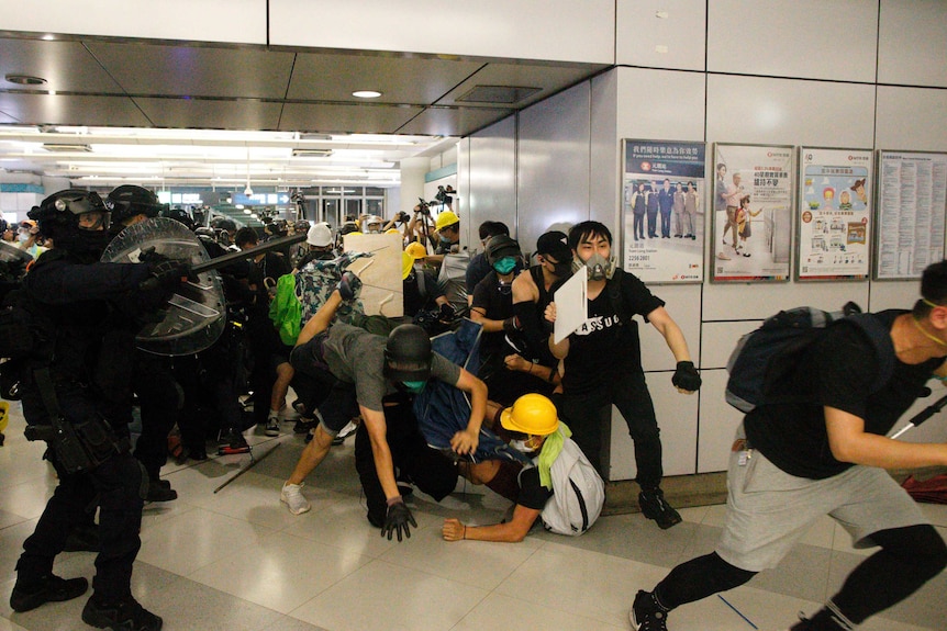 Heavily armoured officers with batons attack protesters who refused to disperse from a train station