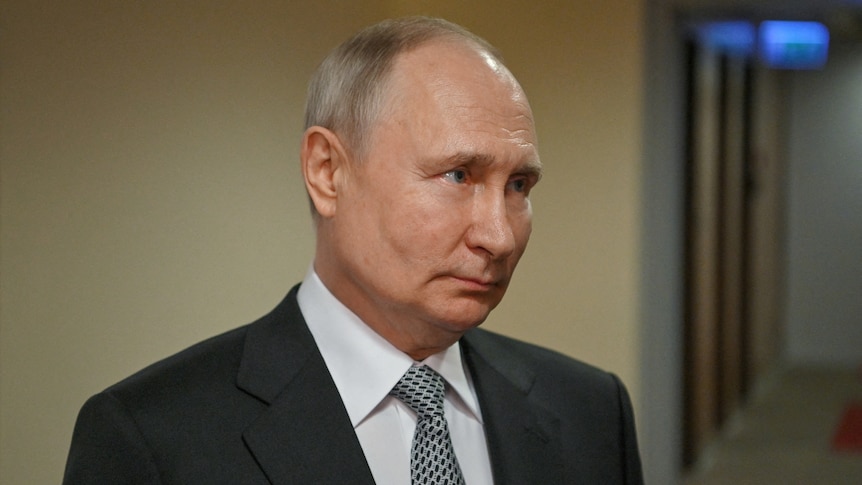 Vladimir Putin wearing a suit, looking off camera