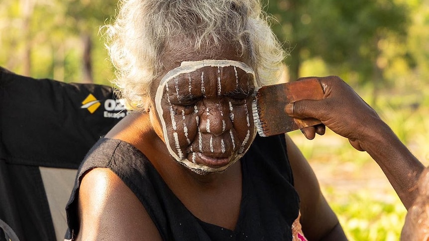 Kaye Brown has her face painted somewhere outdoors on the Tiwi Islands.