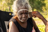 Kaye Brown has her face painted somewhere outdoors on the Tiwi Islands.