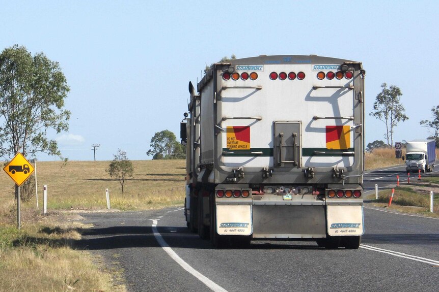 A truck drives along a country highway.
