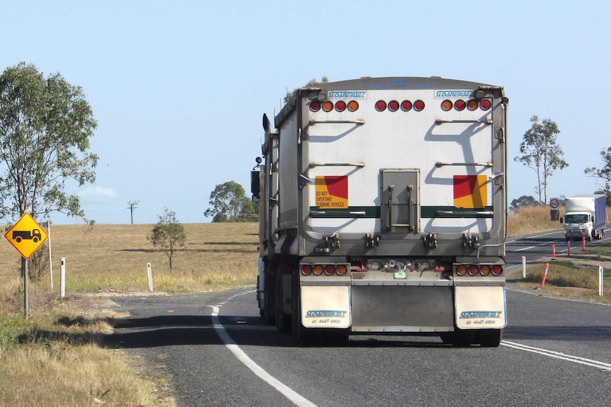 Trucks drive along the Bruce Highway.