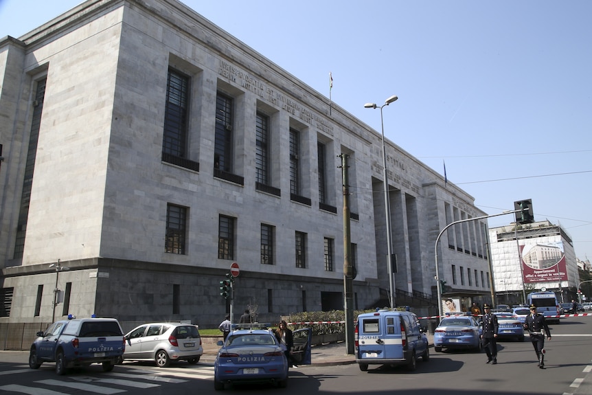 A court building surrounded by police cars