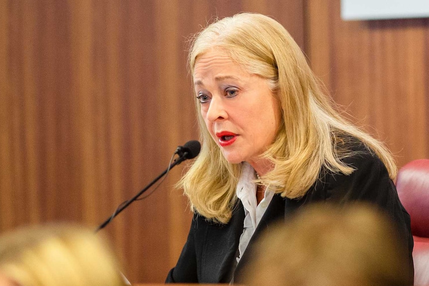 A woman sitting at a legal bench.