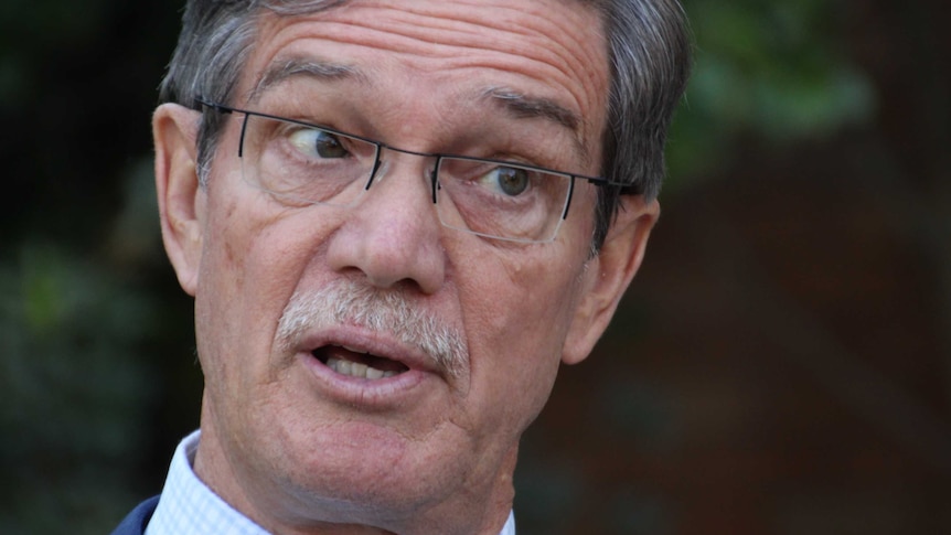 Close up photo of Mike Nahan wearing glasses and speaking.