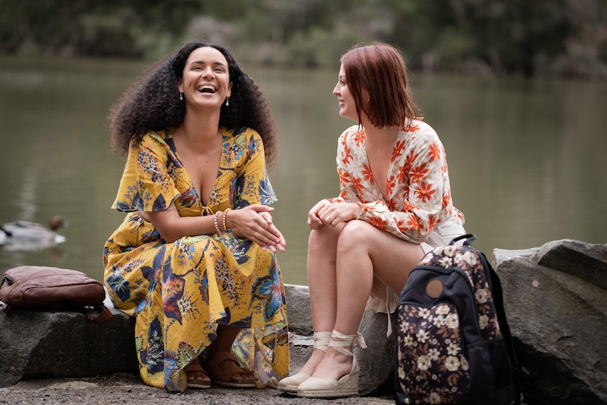 Neighbours characters Kiri and Nicolette laugh outside.