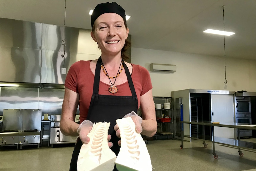 Becky Dart in a commercial kitchen showing a halved and husked piece of bamboo.