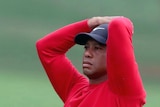 A golfer puts his hands on his head and stares stonily ahead after his shot to the green at Augusta.