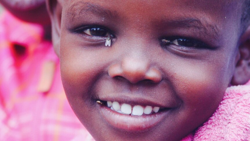 A young Kenyan girl, Setia, smiles for the camera.
