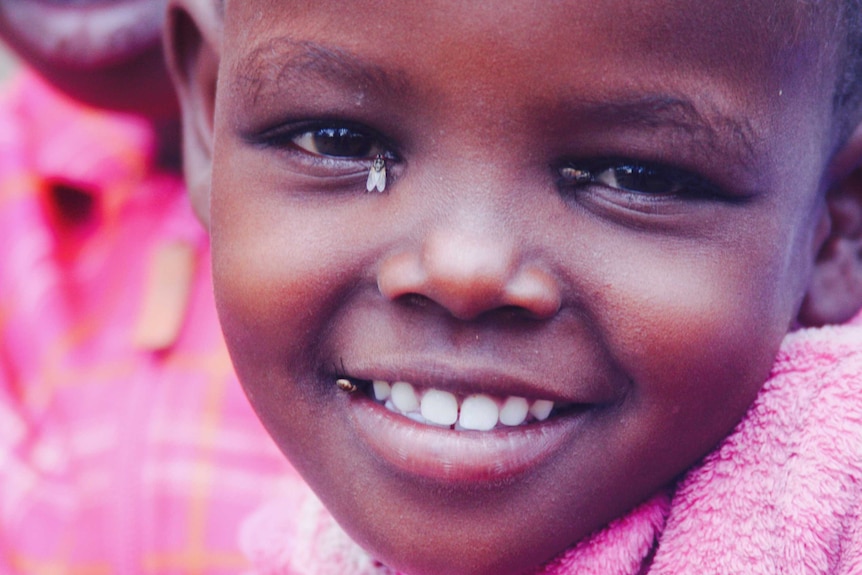 A young Kenyan girl, Setia, smiles for the camera.