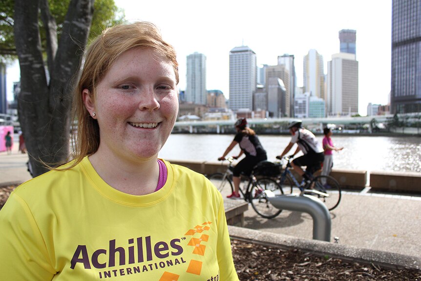 A young woman in a yellow shirt standing in front of a bike path at Southbank, Brisbane.