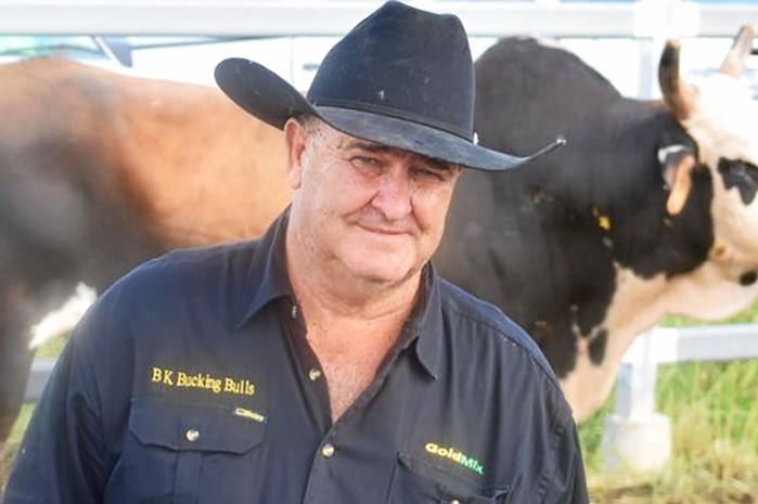 Brian King standing in front of a large bull in a pen