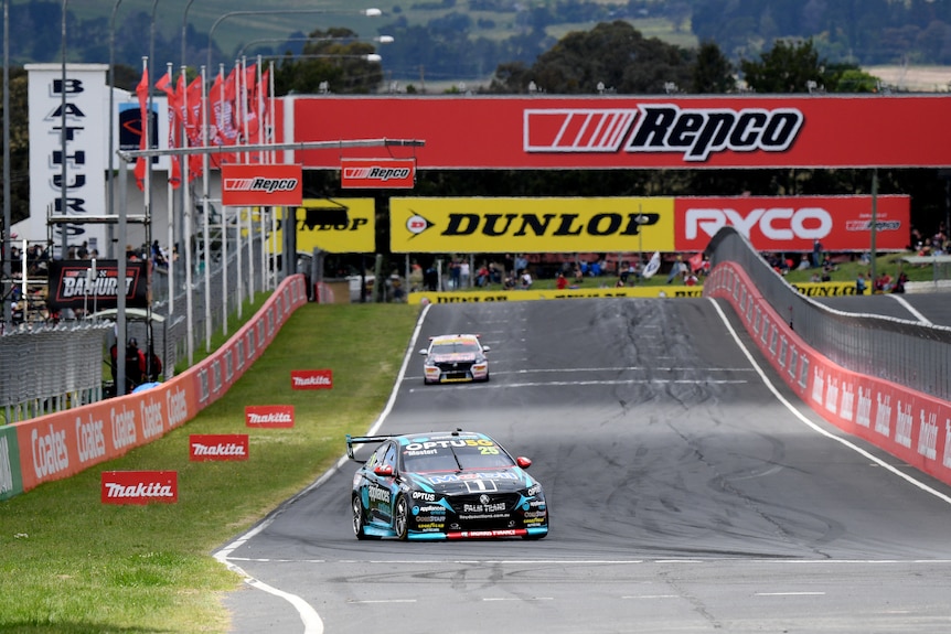 A Holden Commodore supercar turns into a corner a good distance ahead of the next car during the running of the Bathurst 1000. 