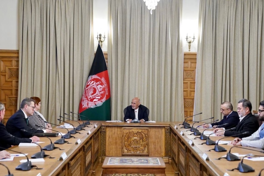 Marise Payne talks with Ashraf Ghani in a formal meeting room, surrounded by advisers