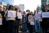 People standing together holding signs 