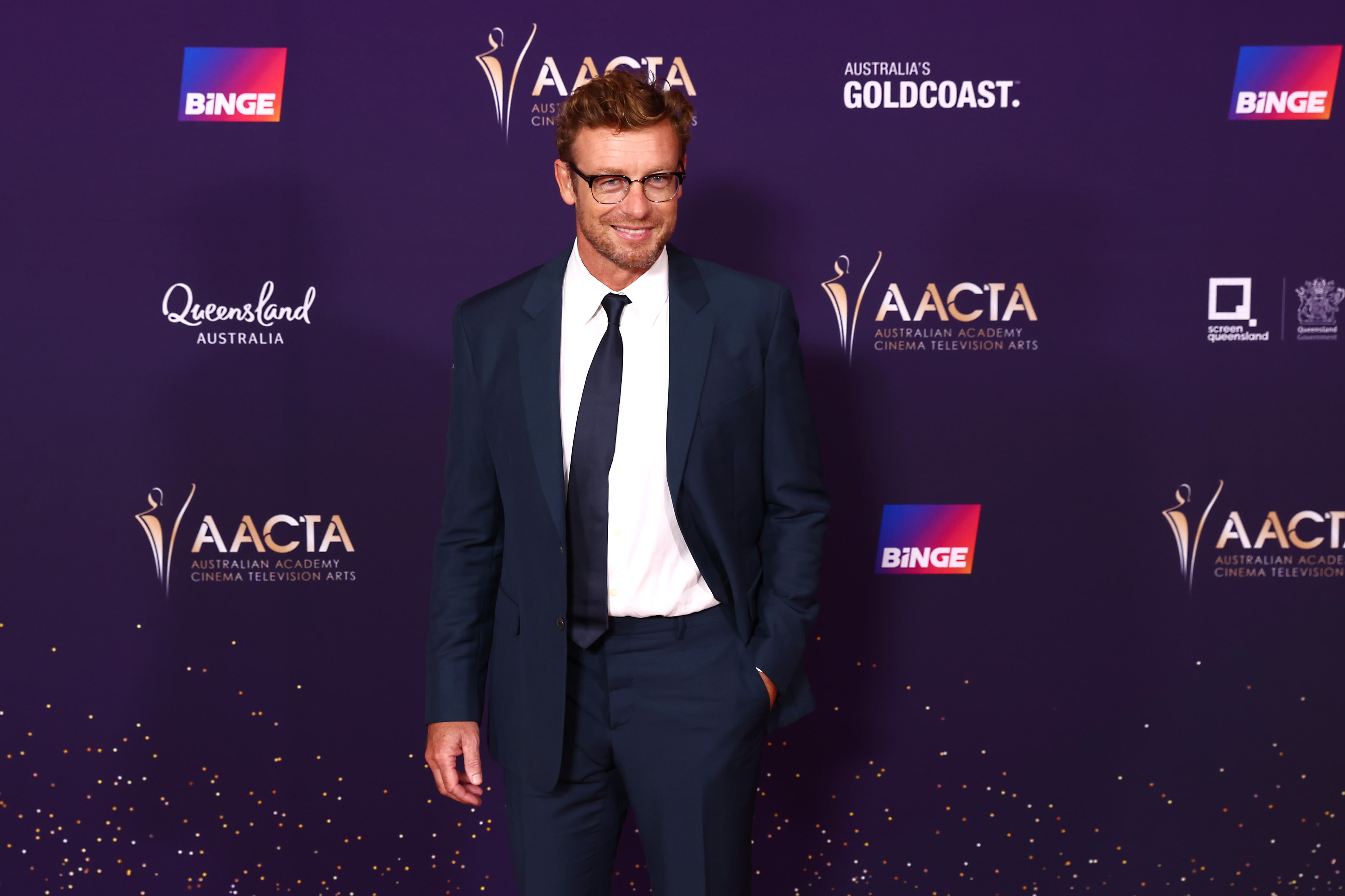 Simon Baker in a navy suit. 