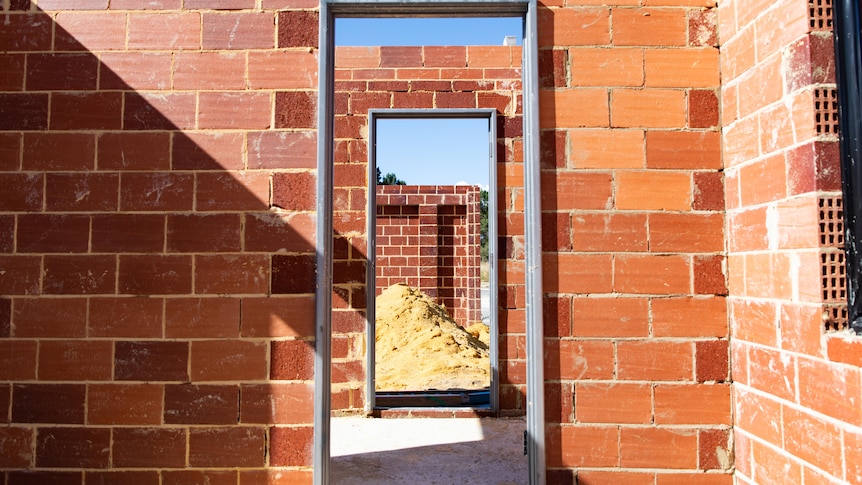 A doorway inside a brick house under construction.