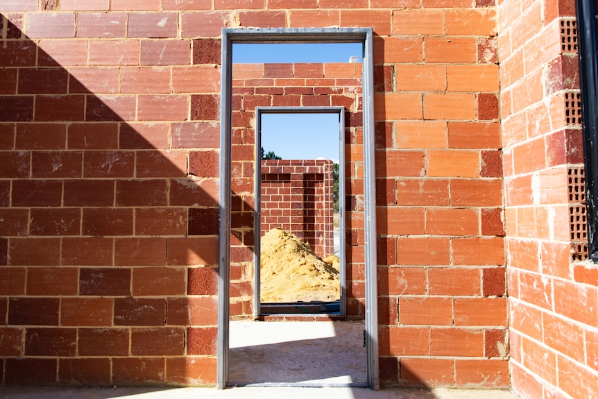 A doorway inside a brick house under construction.