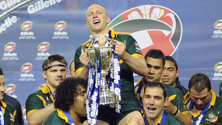 Darren Lockyer lifted up by team-mates holding up Four Nations trophy