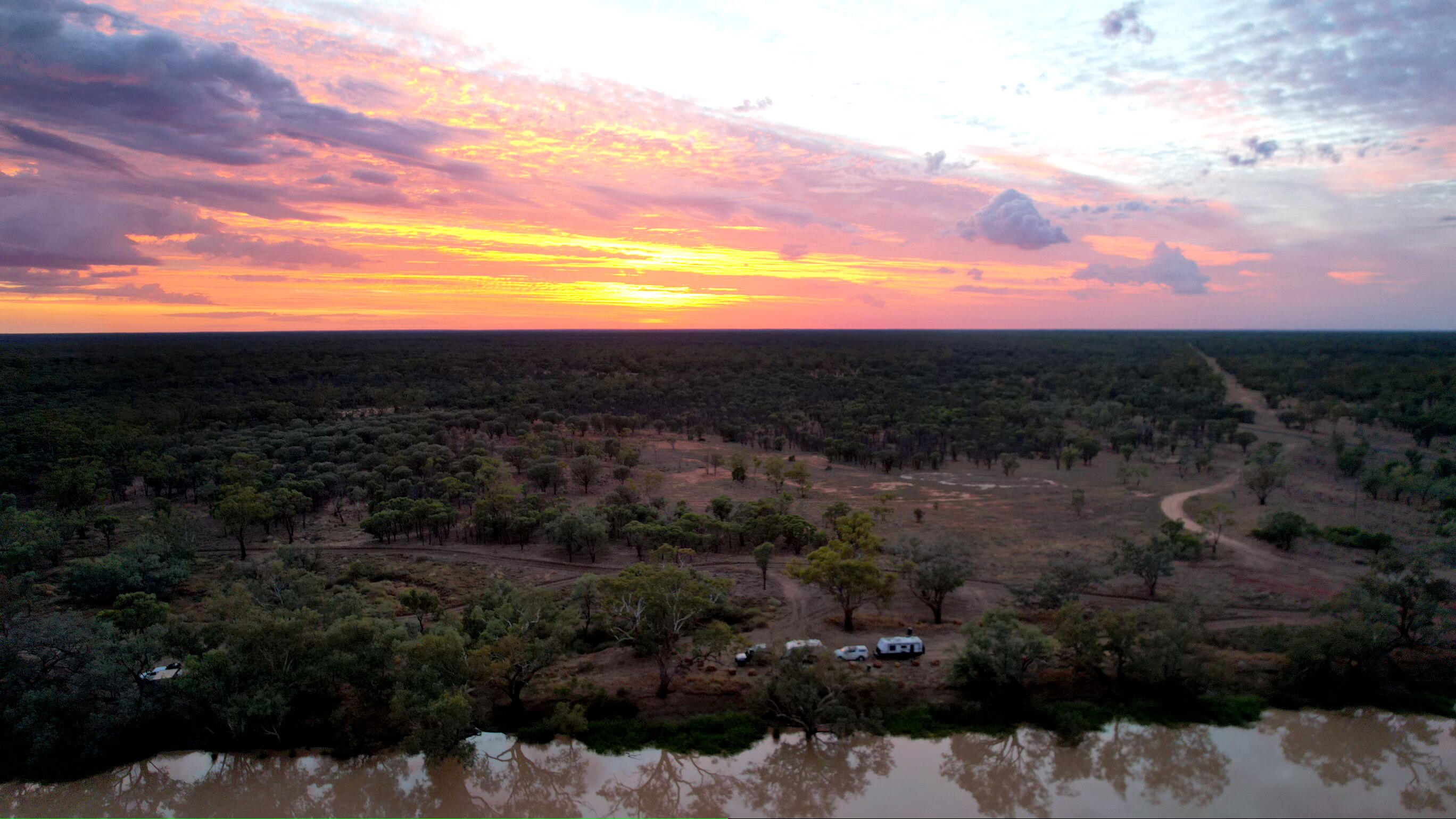 Aerial view of the land from the Ward river at sunrise with two caravans