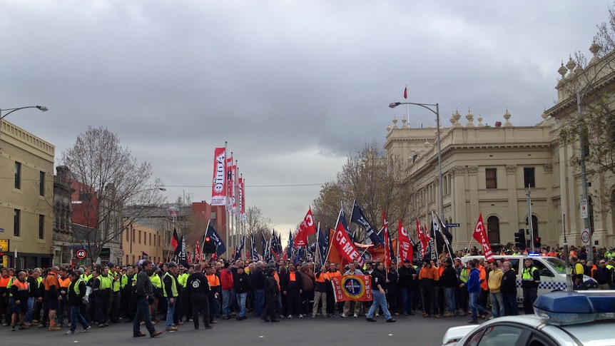 Construction workers rally in Melbourne over new building code rules.