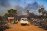 A ute drives into bushfire smoke
