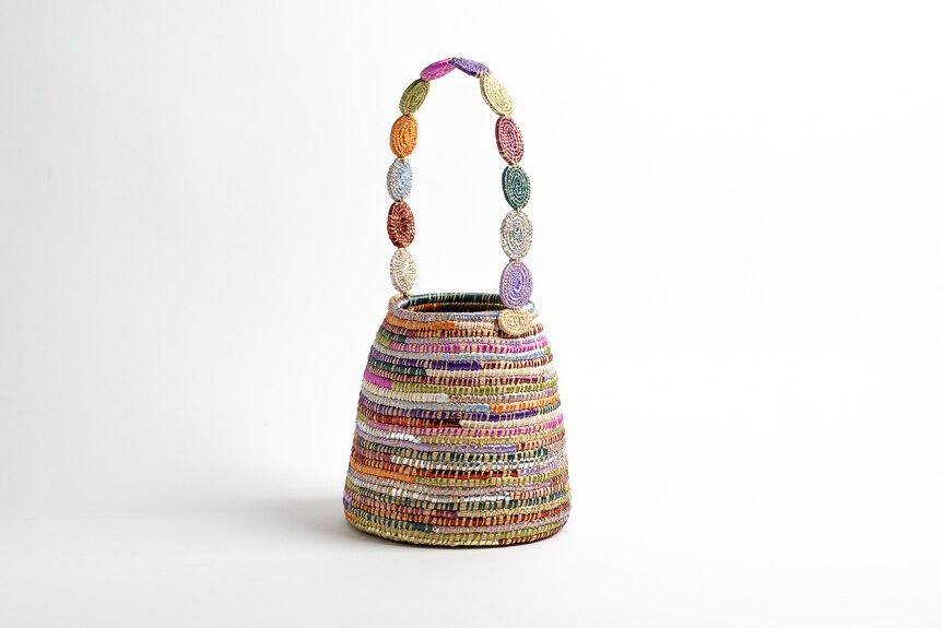 A handbag with a colourful handle.