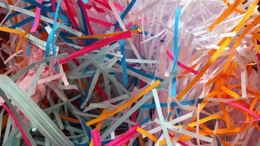 Photo of shreded paper in lots of different colours including pink and yellow 