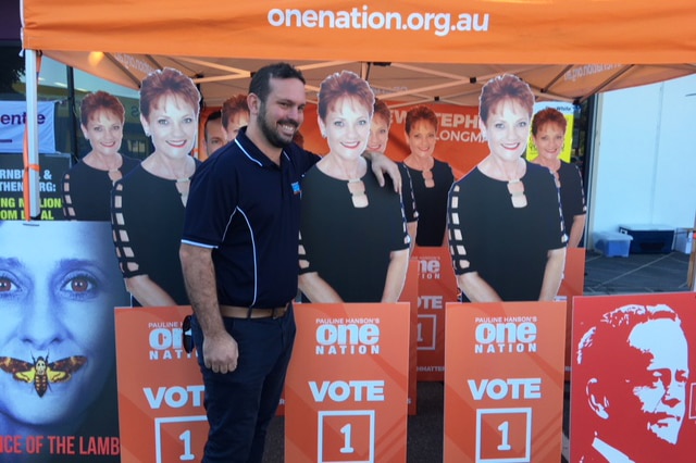 Longman candidate Matthew Stephen stands with arm around a cardboard cutout of One Nation leader Pauline Hanson.