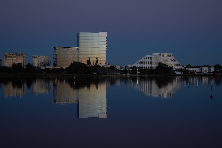 Tall buildings on the banks of a river in the dusk light.