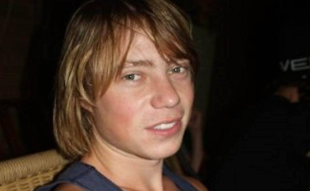 Young man with blonde hair looking into camera