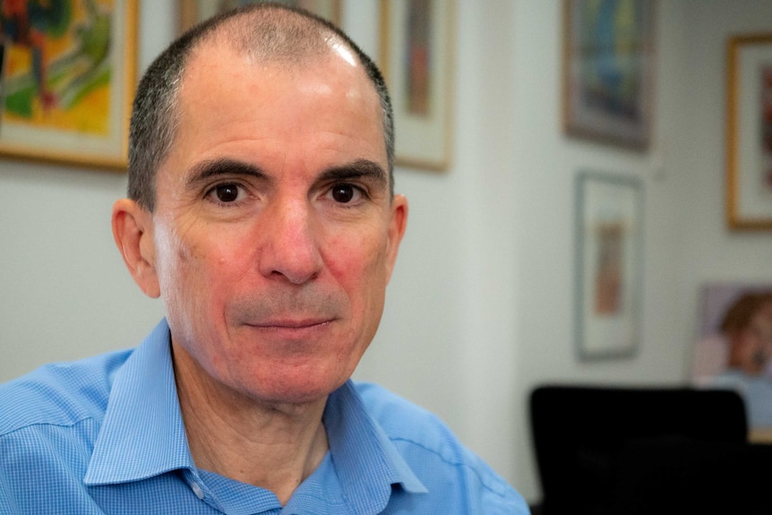 A man looking at the camera sitting in his office