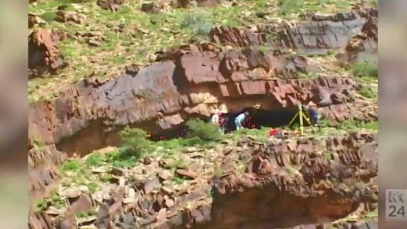 People stand on a cliff-edge at Warratyi prehistoric site