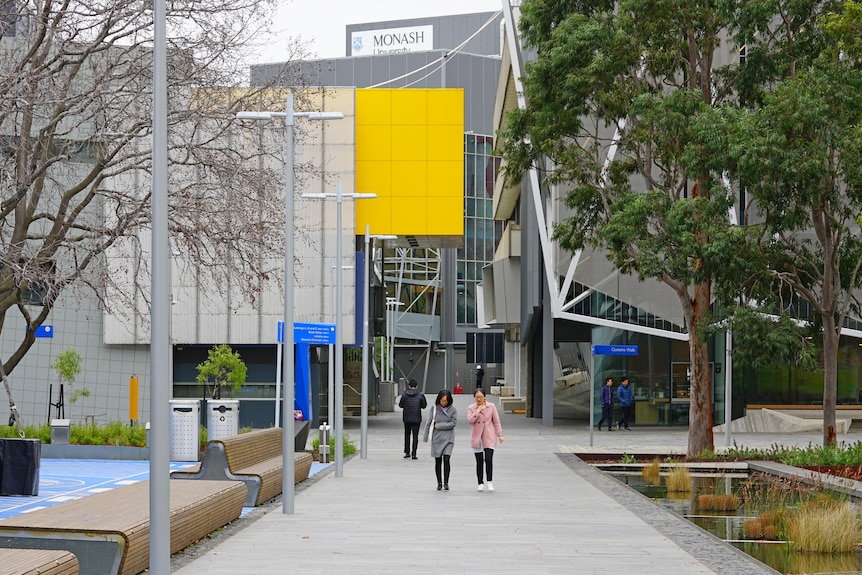 Young people are seen in the distance on the campus of Monash University.
