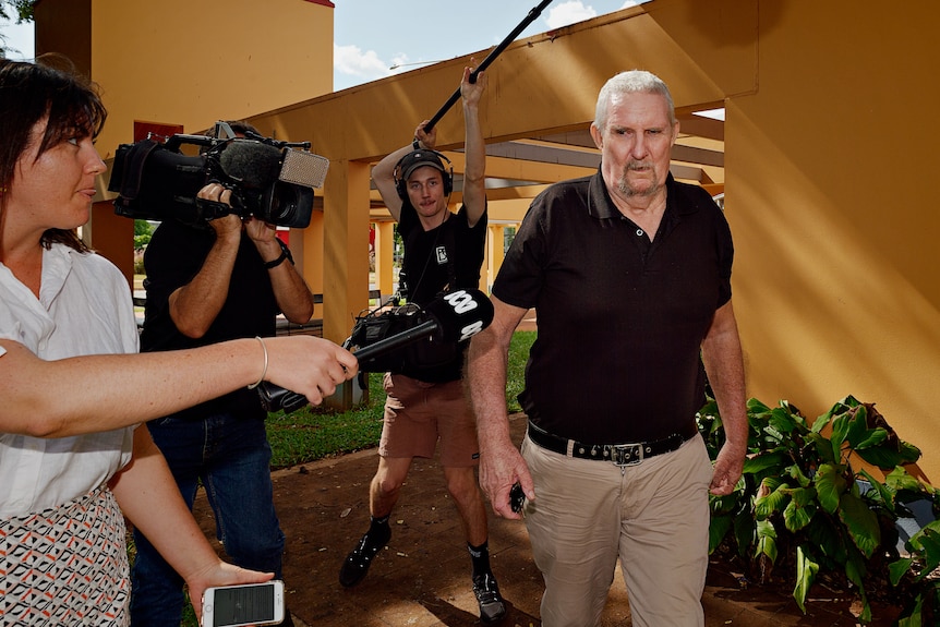 media surround a man leaving court