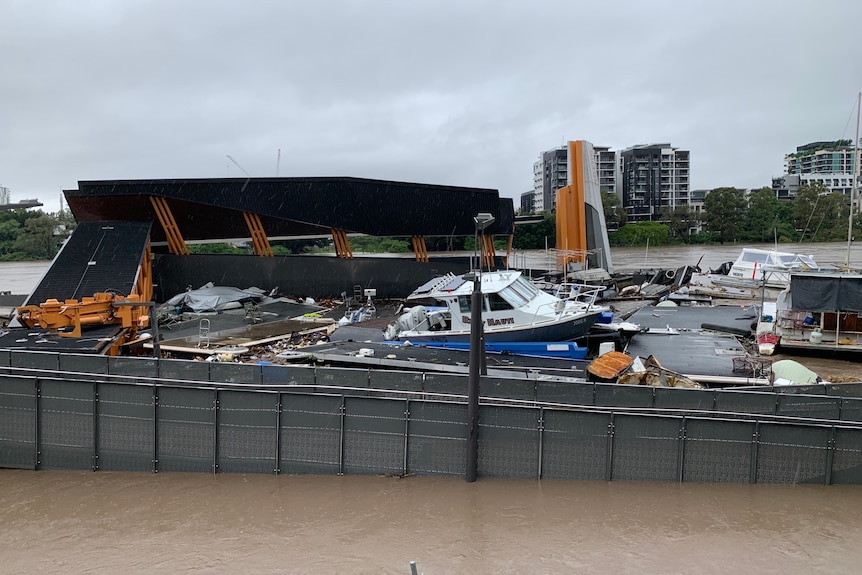 Damage to floating pontoons and boats is seen at a ferry terminal