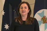 The premier stands in front of the Australian flag.
