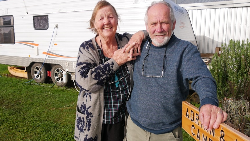 Man and woman standing in front of caravan