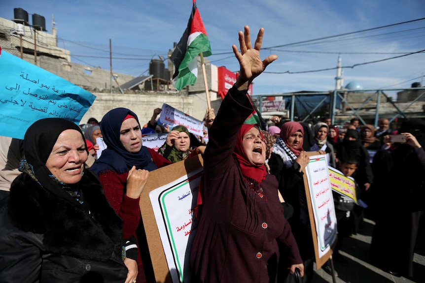 Palestinians take part in a protest against aid cuts outside the UNRWA office in Rafah.