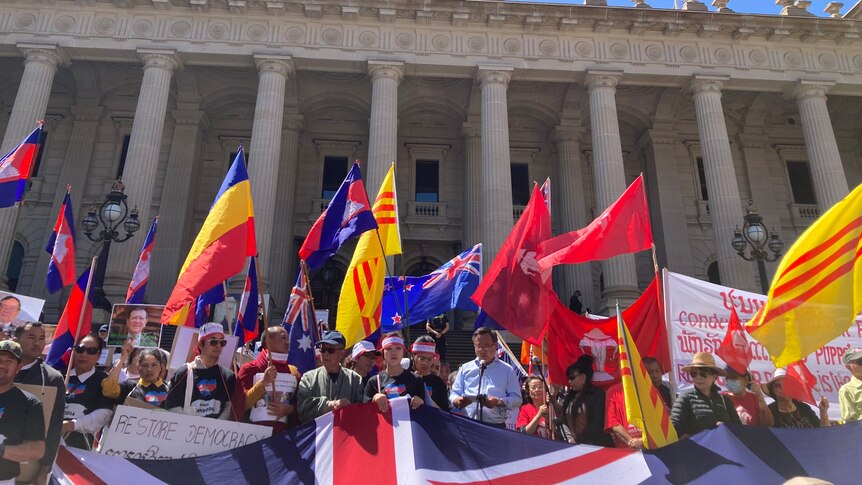 A crowd of people standing with flags.