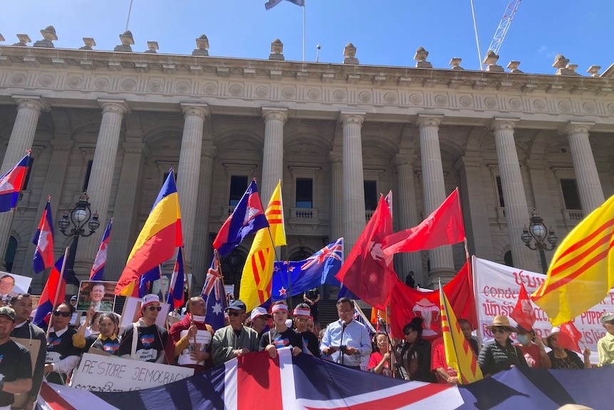 A crowd of people standing with flags.