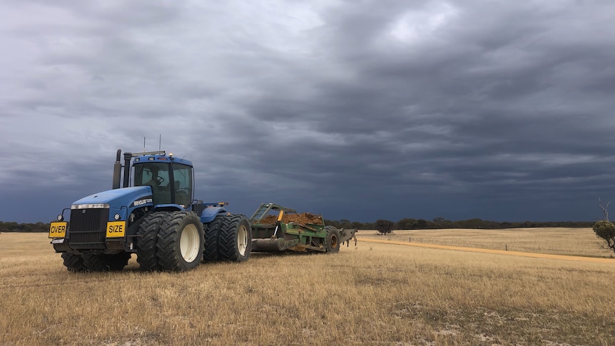 Tractor below brooding storm clouds.