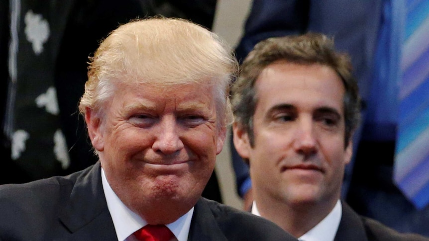 Donald Trump smiles with Michael Cohen in the background