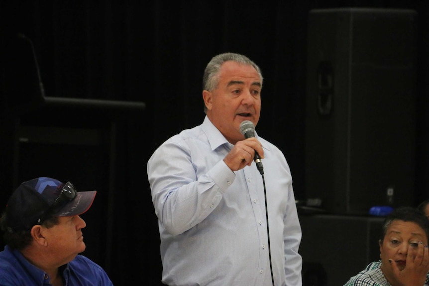 Gerry McCarthy standing with a microphone and speaking on a panel.