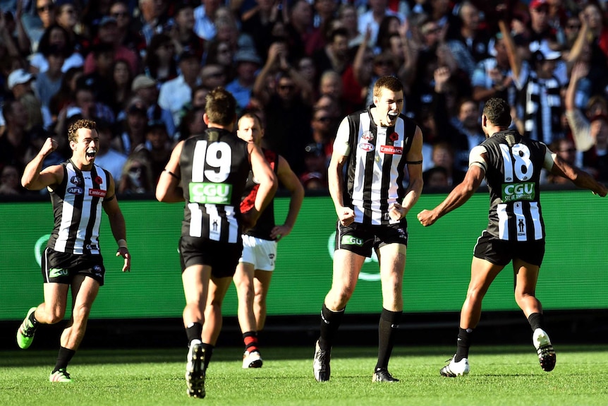 Mason Cox (2R) reacts after kicking a goal for Collingwood against Essendon on Anzac Day, 2016.