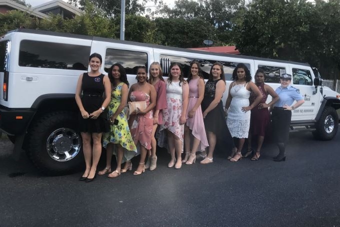 Eight teens in front of a limo graduating from Project Booyah